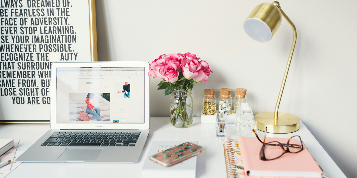 Home office desk with a laptop, phone and notebook, representing increased screen time and remote work.