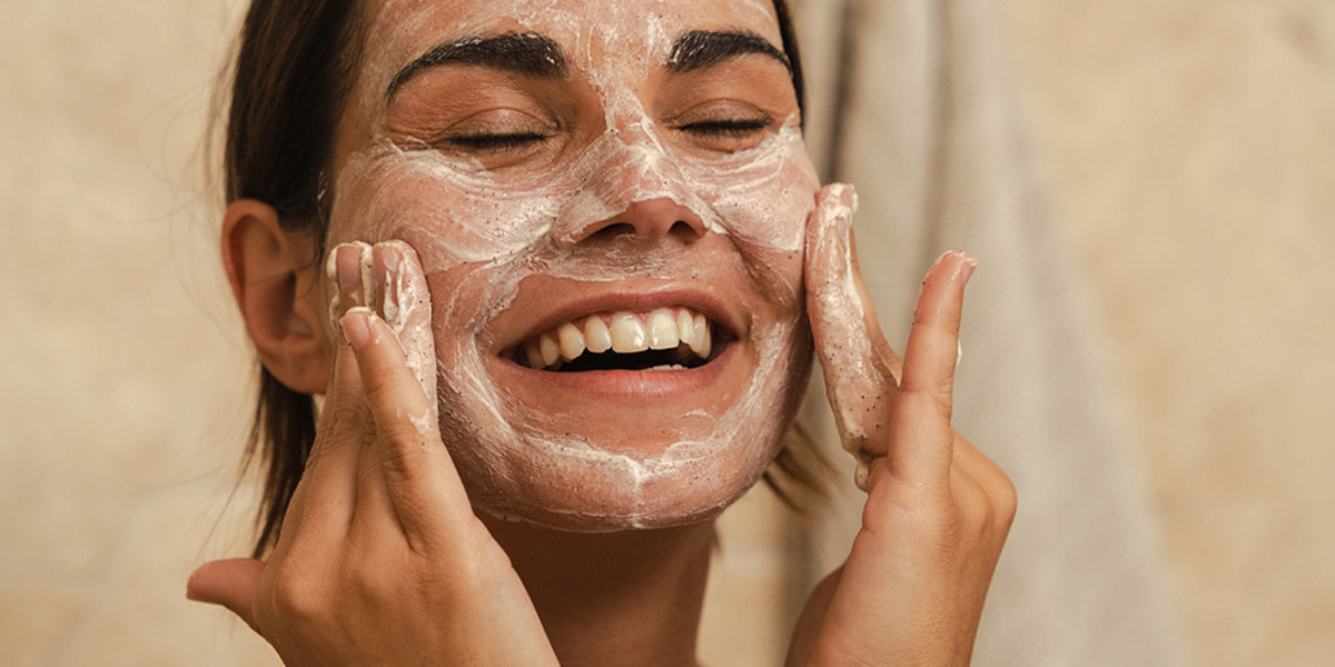Woman applying exfoliating skincare as part of a simplified, minimalist routine.
