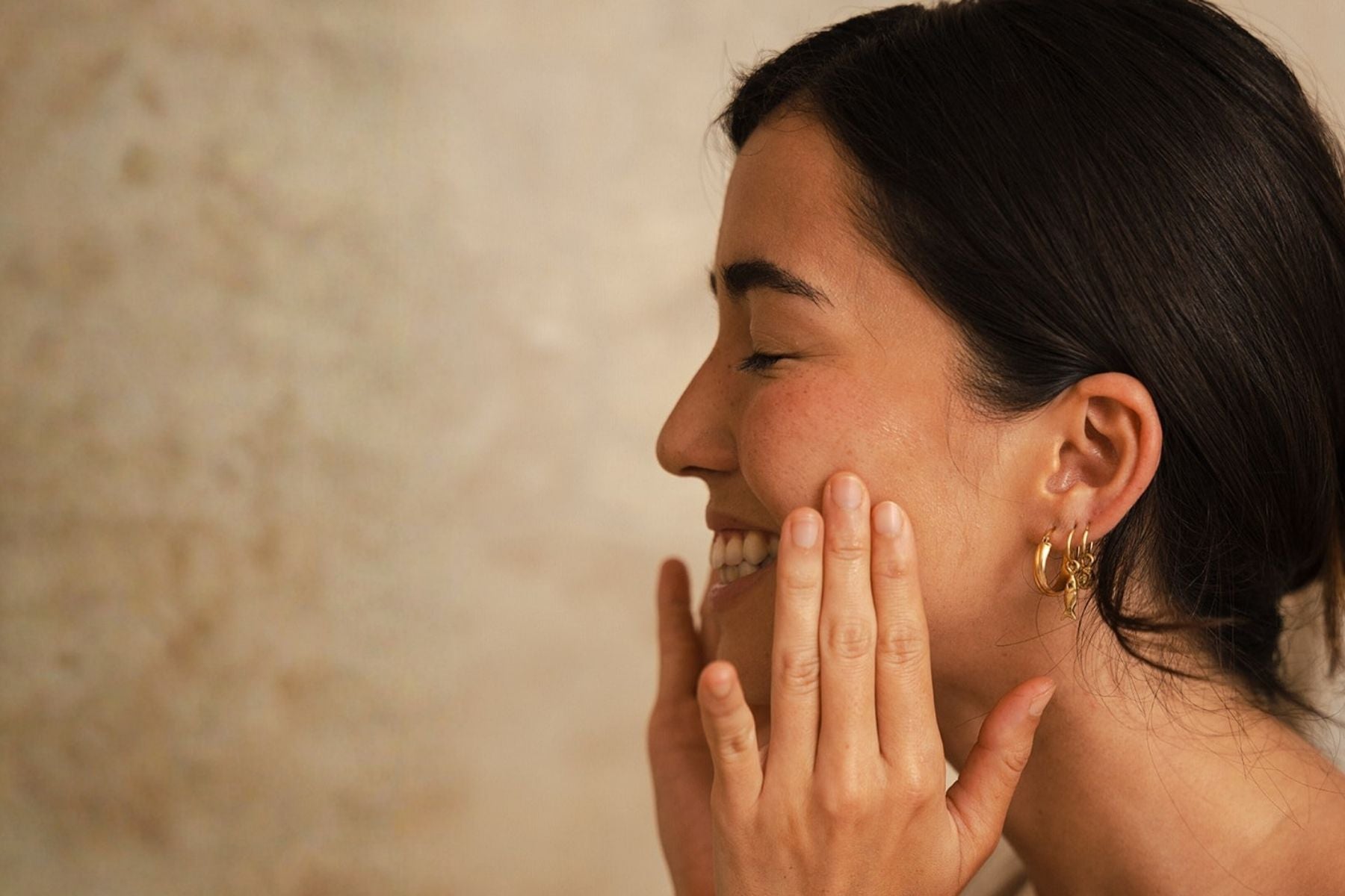 Woman applying Organic Spa facial serum to hydrated skin.