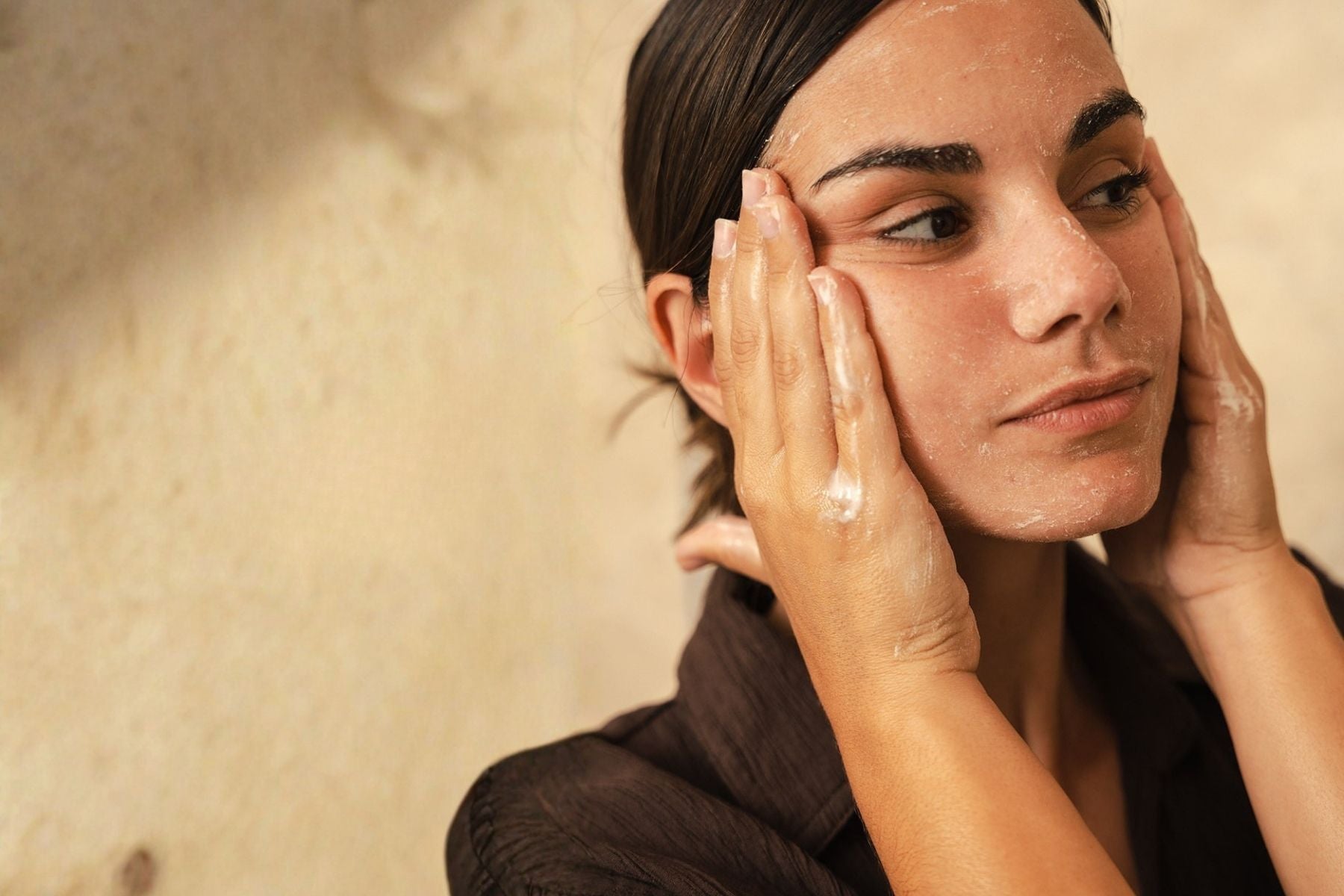 Woman massaging OrganicSpa facial exfoliant to gently polish and smooth skin