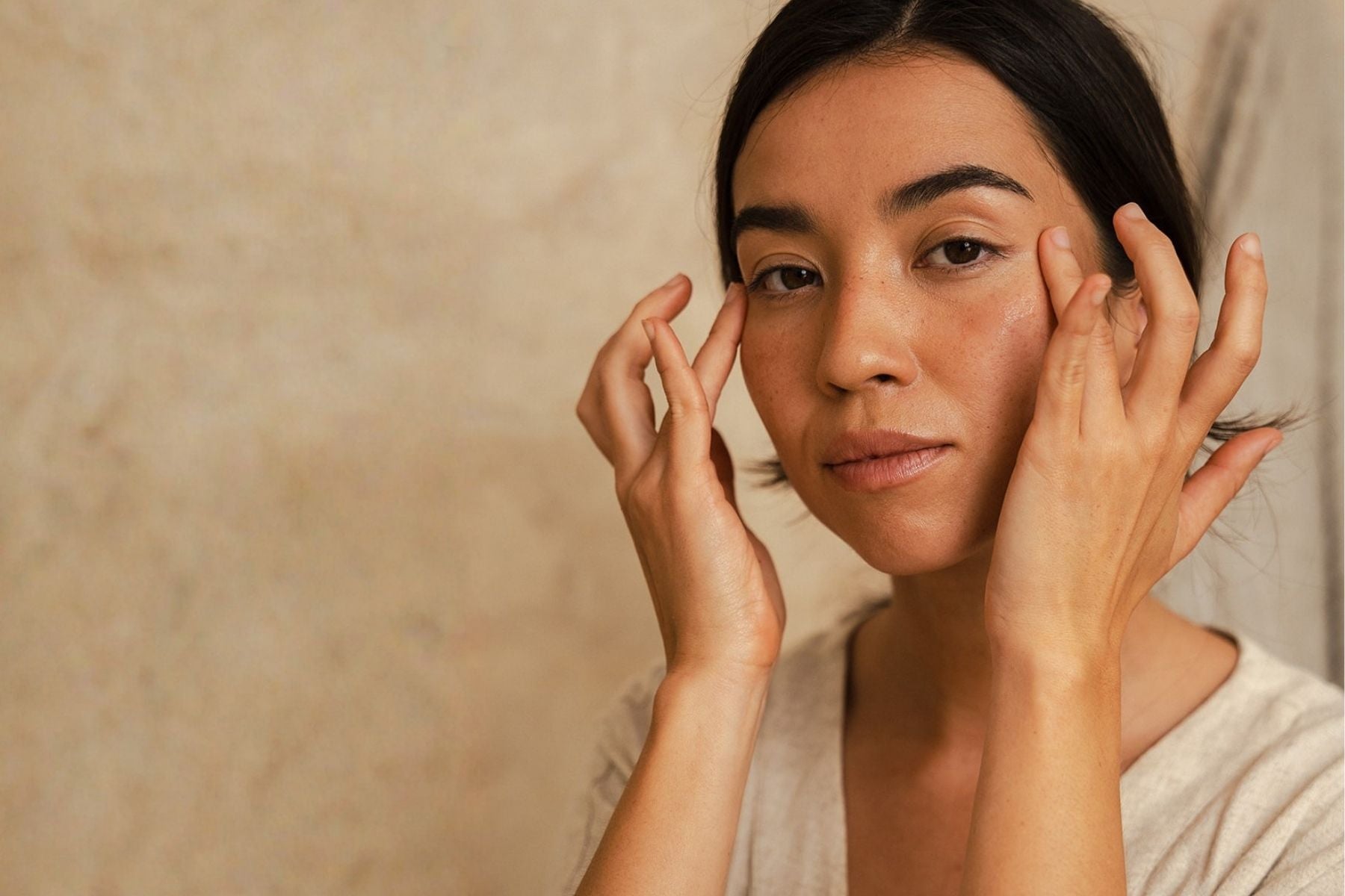 Woman massaging moisturiser into skin for a healthy glow.