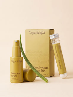OrganicSpa Biohydra+ Serum and Hyaluronic Hydra+ Sheet Mask Trio with glass vial, styled with a fresh aloe vera leaf; Certified Organic hydration products by OrganicSpa.