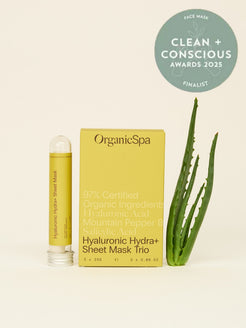 OrganicSpa Hyaluronic Hydra+ Sheet Mask Trio, a chartreuse carton beside a single glass tube of the mask, with fresh aloe leaves alongside. The carton reads 97% Certified Organic Ingredients, Hyaluronic Acid, Mountain Pepper Berry, Salicylic Acid, 3 x 25g. Badge beside it: finalist in the Face Mask category at the Clean + Conscious Awards 2025.