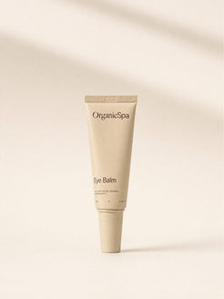 OrganicSpa Eye Balm, a sand-coloured 15ml tube marked 89% Certified Organic Ingredients, in soft light.