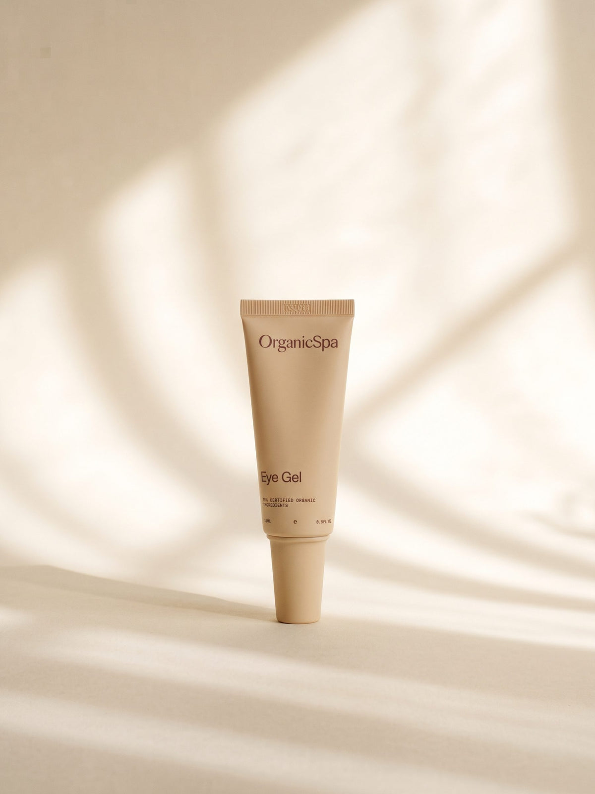 OrganicSpa Eye Gel, a sand-coloured 15ml tube marked 95% Certified Organic Ingredients, in soft light.