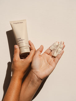 Hands holding Organicspa Face Exfoliant and its creamy scrub texture, certified organic facial exfoliant made in Australia.
