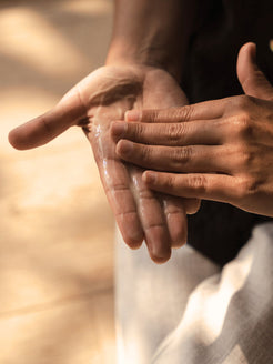 Close-up of hands rubbing together a clear layer of Organicspa Gel Mask, revealing its lightweight gel texture.