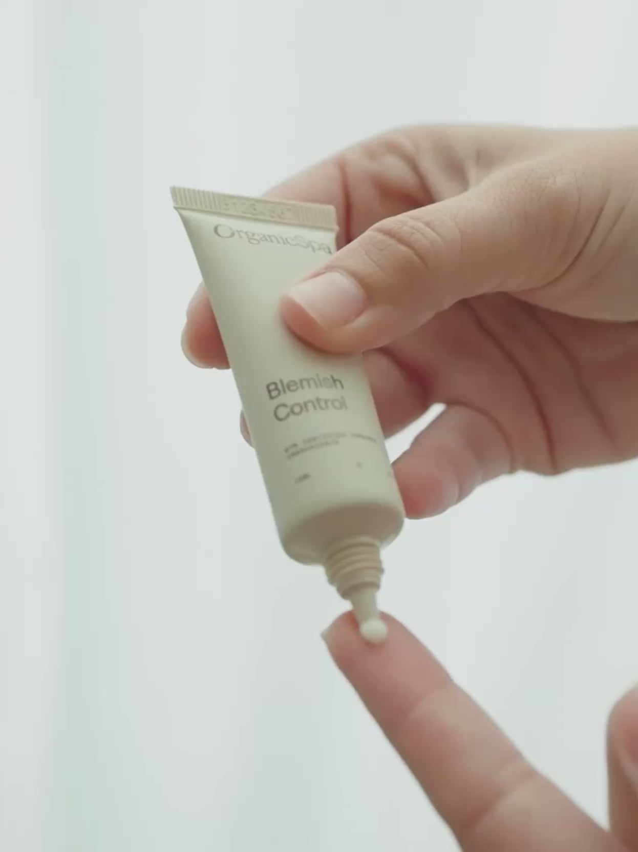 A close-up video of OrganicSpa Blemish Control being squeezed onto fingertip then gently dabbed onto cheek - finishing with product shot.