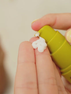 Close-up video of OrganicSpa Reviva-A Complex being dispensed onto a fingertip, showing the creamy white texture, then pumped into an open palm. The product label is visible in the second frame. Certified Organic Skincare.